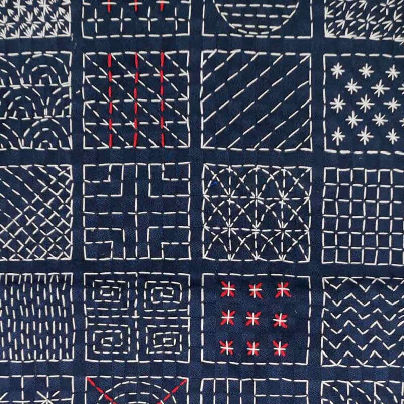 stickmuster der sashikotechnik auf indigo gefärbten stoff